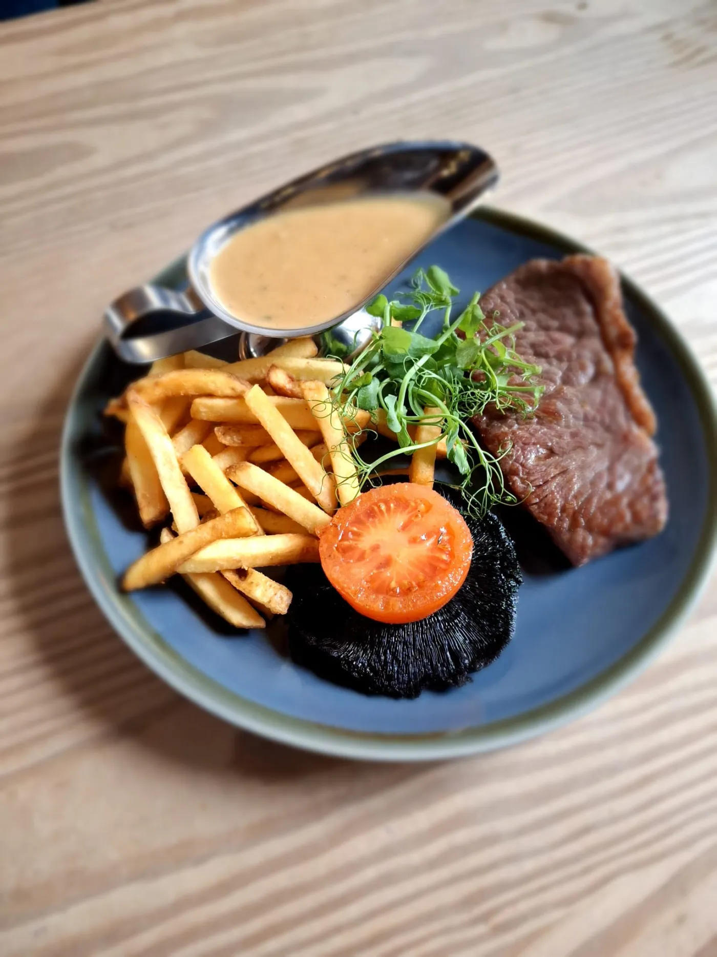 Steak with fries, tomato and sauce served at The Strand